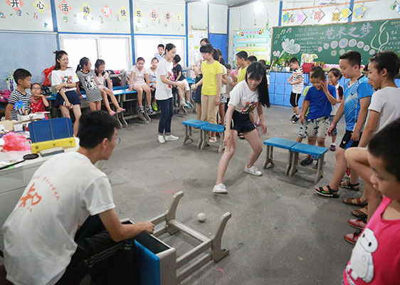 溫州大學(xué)“知心姐姐”暑期社會實(shí)踐隊(duì)到浙江樂清市開展支教活動，為當(dāng)?shù)剜l(xiāng)村中小學(xué)生普及奧林匹克教育，圖為志愿者示范“投球進(jìn)框”動作。